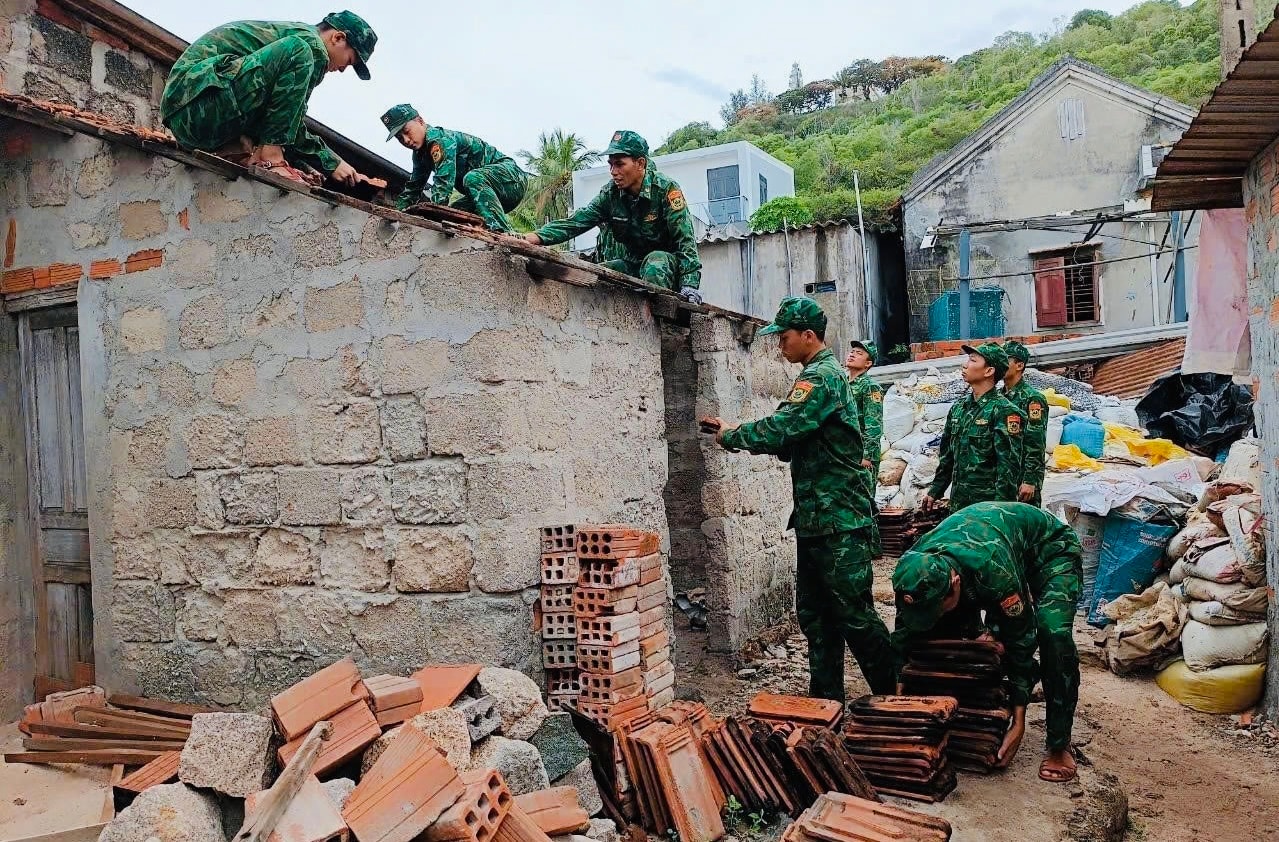 Cán bộ chiến sĩ tham gia xóa nhà tạm, nhà dột nát trên địa bàn. (ảnh Đ.S)