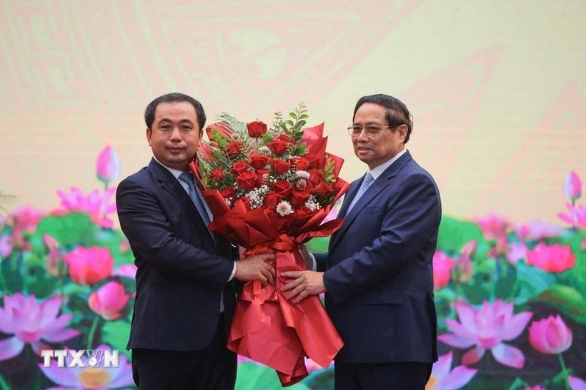 Thủ tướng Phạm Minh Chính tặng hoa chúc mừng quyền Bộ trưởng Bộ Nông nghiệp và Môi trường Trần Đức Thắng. (Ảnh: Hoàng Hiếu/TTXVN)