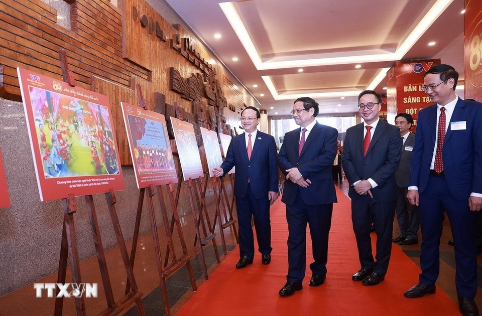 Thủ tướng Phạm Minh Chính tham quan trưng bày ảnh về quá trình hình thành và phát triển của Đài Tiếng nói Việt Nam. (Ảnh: Dương Giang/TTXVN)